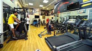 Un gimnasio con cintas de correr, máquinas de pesas y una amplia variedad de equipamiento de fitness.