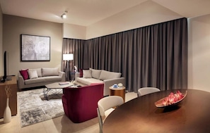 Relax in a stylish space with a sofa, armchairs, and a dining table.