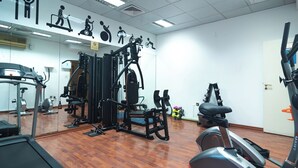 A gym with various exercise equipment, including treadmills, weight machines, and a stationary bike.