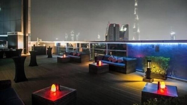 A rooftop lounge with seating areas and a view of the Burj Khalifa. - Deluxe Room Near Financial Centre (دبي)