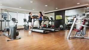 A gym with treadmills, ellipticals, and weight machines. - Deluxe Room Near Financial Centre (دبي)