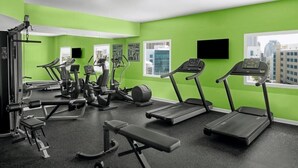 A gym with treadmills, elliptical machines, and weight benches.