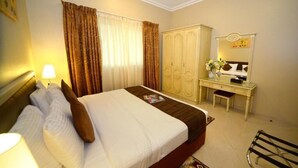 Ein Hotelzimmer mit Bett, Schreibtisch, Kleiderschrank und Spiegel.