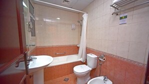 A bathroom with a bathtub, toilet, bidet, and sink. - Studio Apartment Near Al Khan Beach By E R (الشارقة)