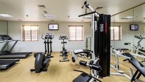 A gym with treadmills, elliptical machines, and weightlifting equipment.