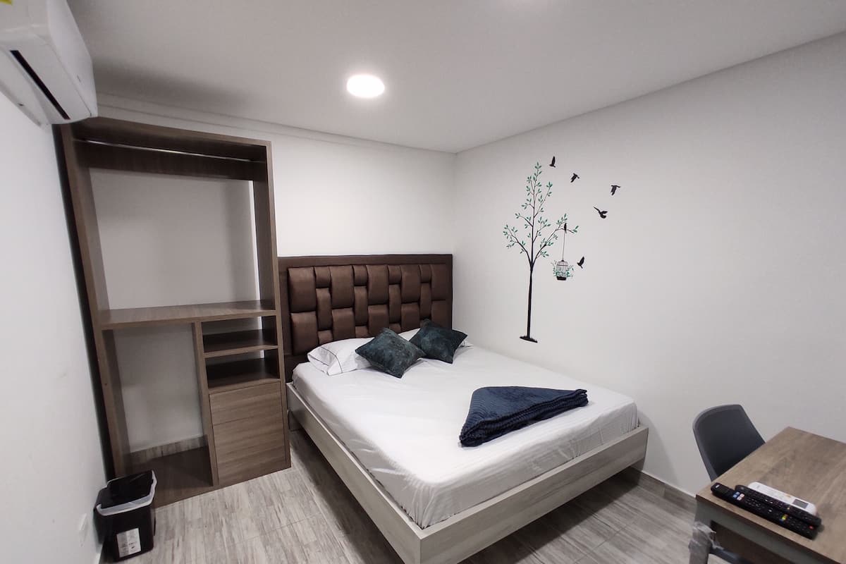 Quarto com cama, escrivaninha e guarda-roupa.
