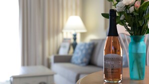 A bottle of Chateau Chantal sparkling wine on a table with a vase of flowers.