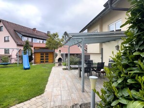 A patio area with a grill, seating, and a slide. - Apartment 'Ferienwohnung 2' with Shared Garden, Balcony and Wi-Fi (Wasserburg (Bodensee))