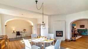 A modern dining area with a round table, white chairs, and a chandelier. - Holiday Apartment "Merkurblick" with Mountain View & Private Terrace, WLAN (Baden-Baden)