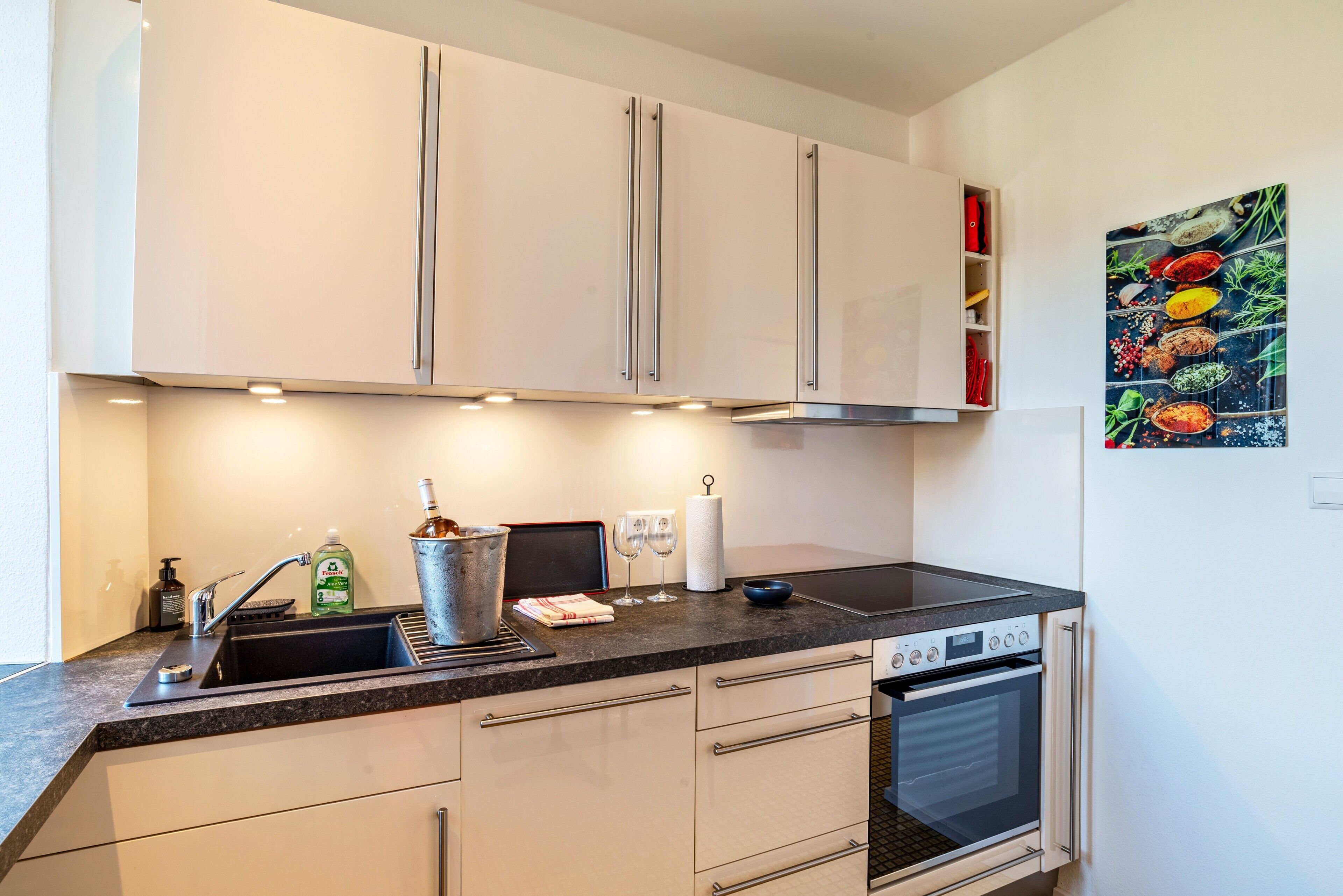 A modern kitchen with a sink, stove, and cabinets.