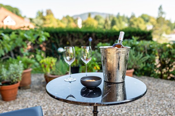 A round table with a metal bucket, two wine glasses, and a bowl.