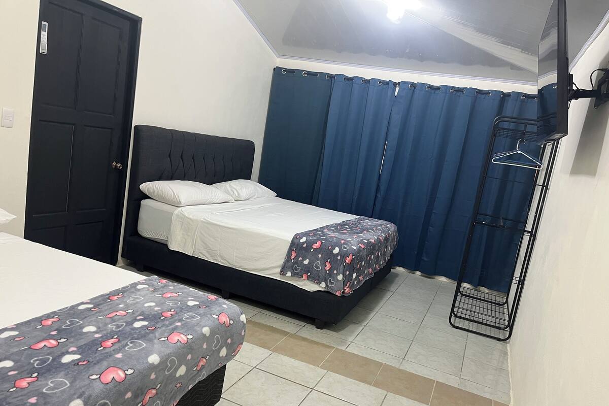 Ein Schlafzimmer mit einem Bett, einem Nachttisch, einem Kleiderschrank und einer Kleiderstange.