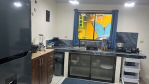 Una cocina moderna con refrigerador, estufa, pileta y alacenas.