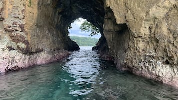 Ein natürlicher Felsbogen über klarem Wasser.