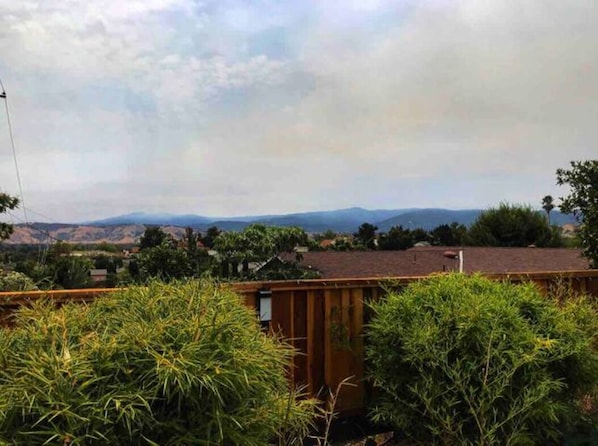 A residential area with a view of distant hills and a cloudy sky.