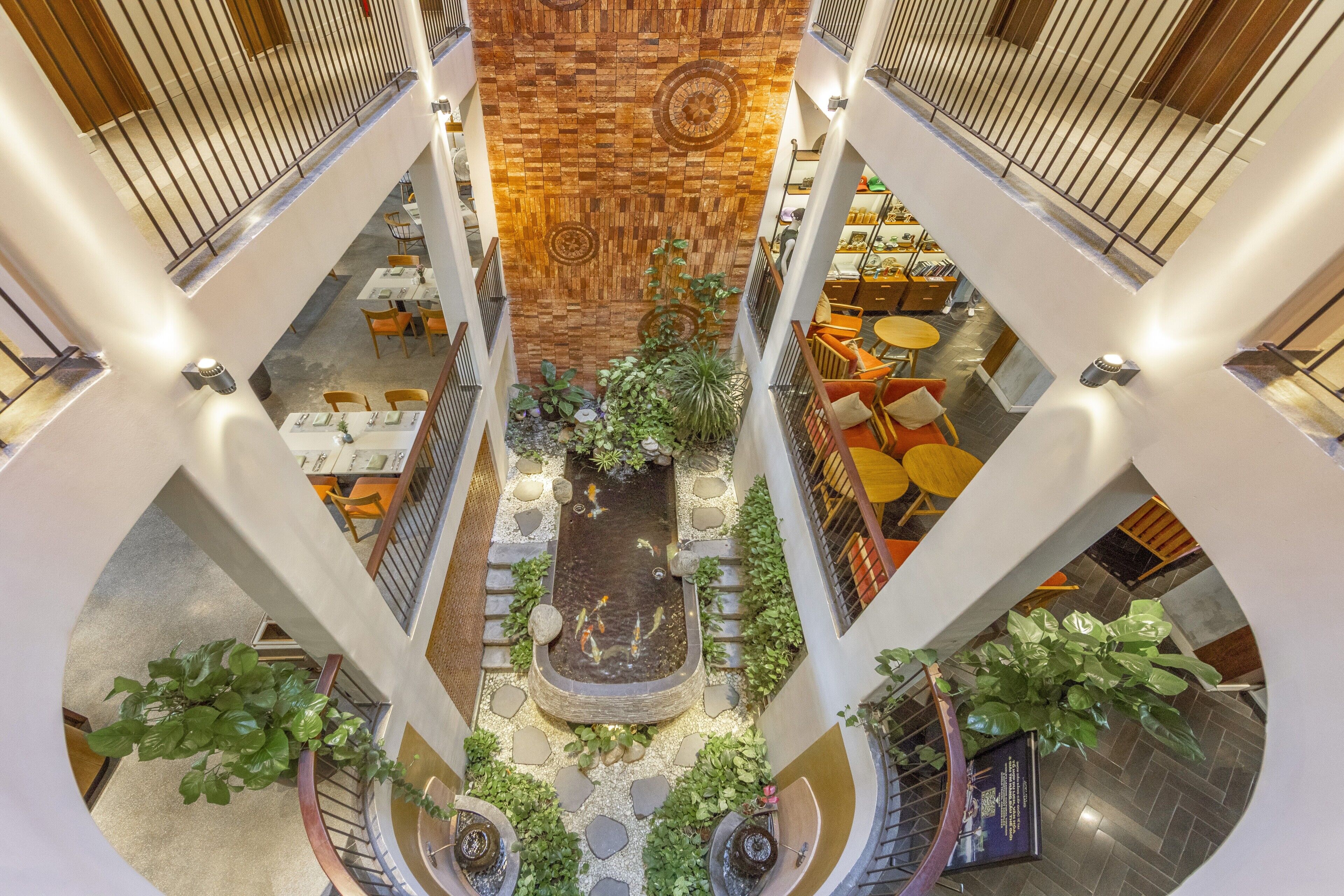 A multi-level atrium with a central water feature, surrounded by seating areas and plants.