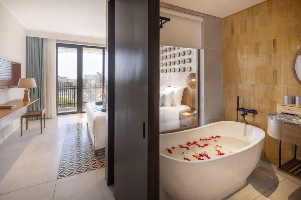 Une salle de bain moderne avec une baignoire sur pieds, un grand miroir et un espace douche.