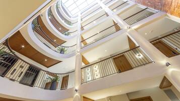 A multi-level atrium with a central open space, railings, and potted plants.