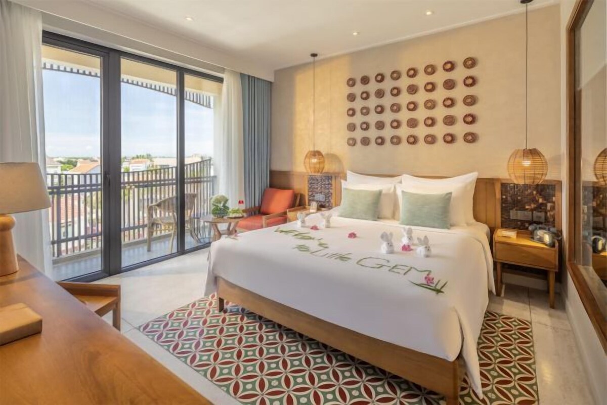Un cuarto de hotel con una cama grande, un balcón y vistas de la ciudad.