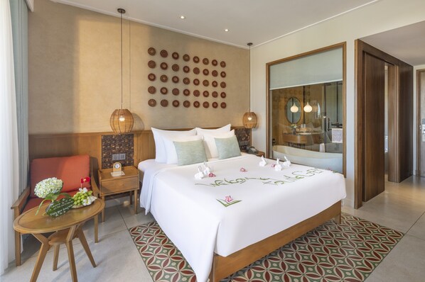 Une chambre d’hôtel avec un grand lit, des tables de chevet, un miroir et un mur décoré de motifs circulaires.