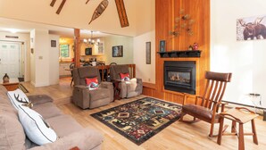 A cozy living room with a fireplace, wooden furniture, and a patterned rug. - Spacious Home near Diana's Baths! (Conway)