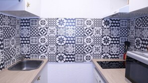 A kitchen with patterned tiles, a sink, and a microwave. - LARGE STUDIO 6 PEOPLE RESORT CENTER (LES ORRES 1650)