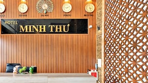 A hotel reception desk with clocks displaying times from New York, Hanoi, Tokyo, and Beijing.