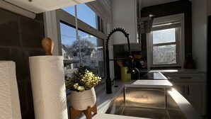 Una cucina moderna con un'ampia finestra, un lavello e un tagliere di legno.