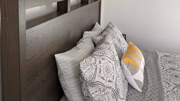 A bedroom with a wooden headboard, a patterned bedspread, and a cityscape painting on the wall.