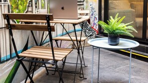 A small outdoor seating area with a table, chairs, and a laptop. - Espectacular depto con terrazas en Condesa (Ciudad de México)