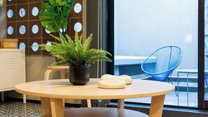 A modern interior with a round wooden table, a potted plant, and a blue chair. - Espectacular depto con terrazas en Condesa (Ciudad de México)