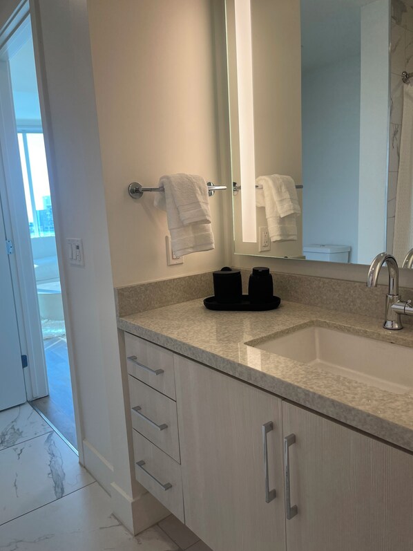 Un baño moderno con un espejo grande, un lavabo y un perchero para toallas.
