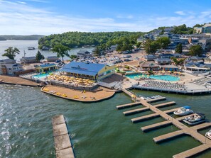 A waterfront property with a pool area, dock, and a building with a blue roof.
