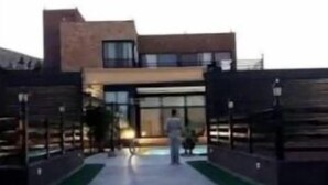 A modern building with a glass facade and a paved entrance area.