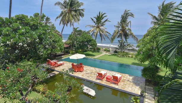 A pool area with lounge chairs and a view of the ocean. - A quiet oasis in the traditional north of Bali right by the sea (Kubutambahan)