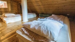 Une cabane avec un lit en mezzanine, un radiateur et une fenêtre.