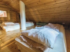 Een houten kamer met een bed, een kussen en een grote witte kolom.