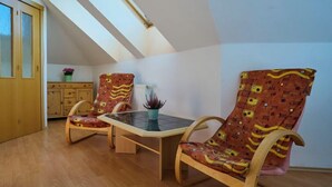 Un coin repas comprenant une table et deux chaises, un meuble en bois et un radiateur.