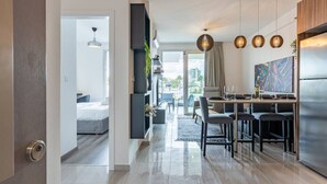Une cuisine moderne avec un coin repas, un four encastré et des luminaires suspendus.