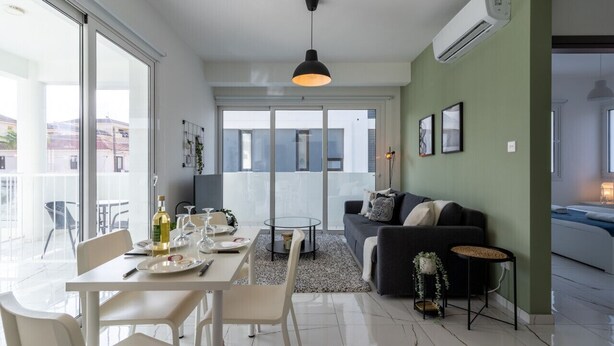 Een moderne woonkamer met een eethoek, een bank en een balkon.