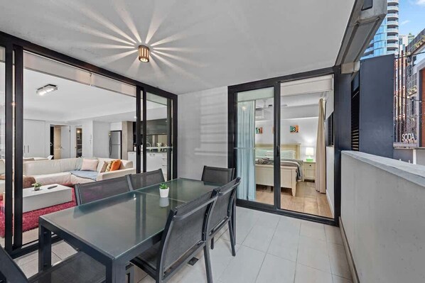 A modern apartment with a dining area, kitchen, and living space.