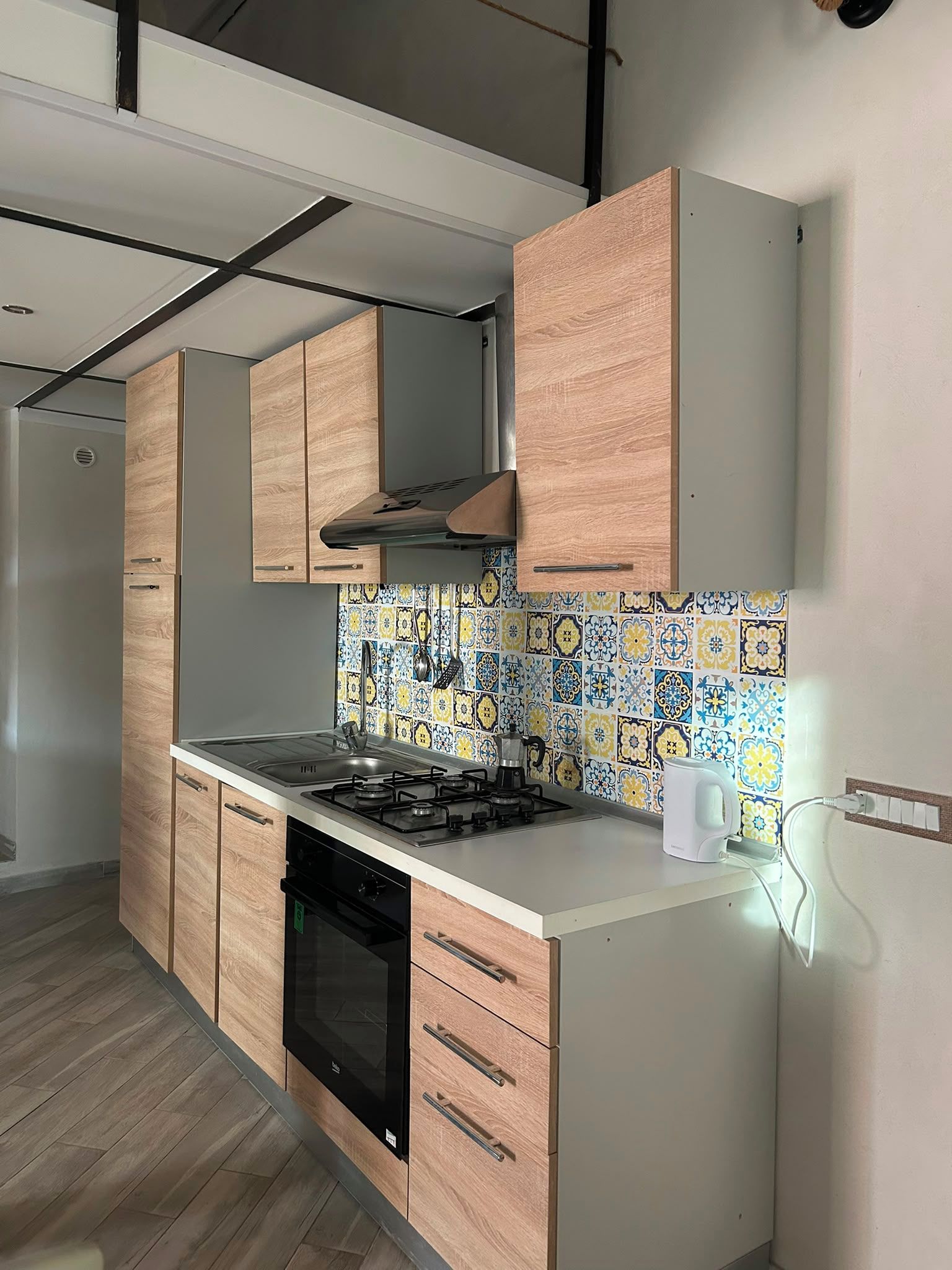 Une cuisine moderne avec des meubles en bois, une cuisinière à gaz et un lave-vaisselle.