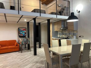 Un intérieur moderne comprenant un coin repas, une cuisine et un canapé.