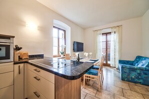 A modern kitchen with a marble countertop, wooden cabinets, and a built-in oven. - Apartment 'Linslhof Quarz' with Mountain View, Shared Terrace and Wi-Fi (Terlano)