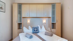 A hotel room with a bed, two side tables, a wardrobe, and two wall-mounted lights. - Apartment 'Linslhof Terlaner' with Mountain View, Private Terrace and Wi-Fi (Terlano)