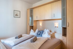Ein Hotelzimmer mit einem Bett, einem Nachttisch, einem Spiegel und einer Wandleuchte.