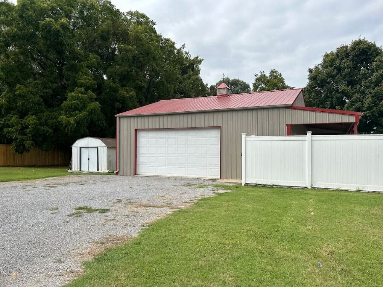 A single-story building with a red roof and a white garage door.