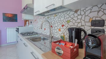 Een koelkast, een oven, een kookplaat, een koffiezetapparaat/waterkoker
