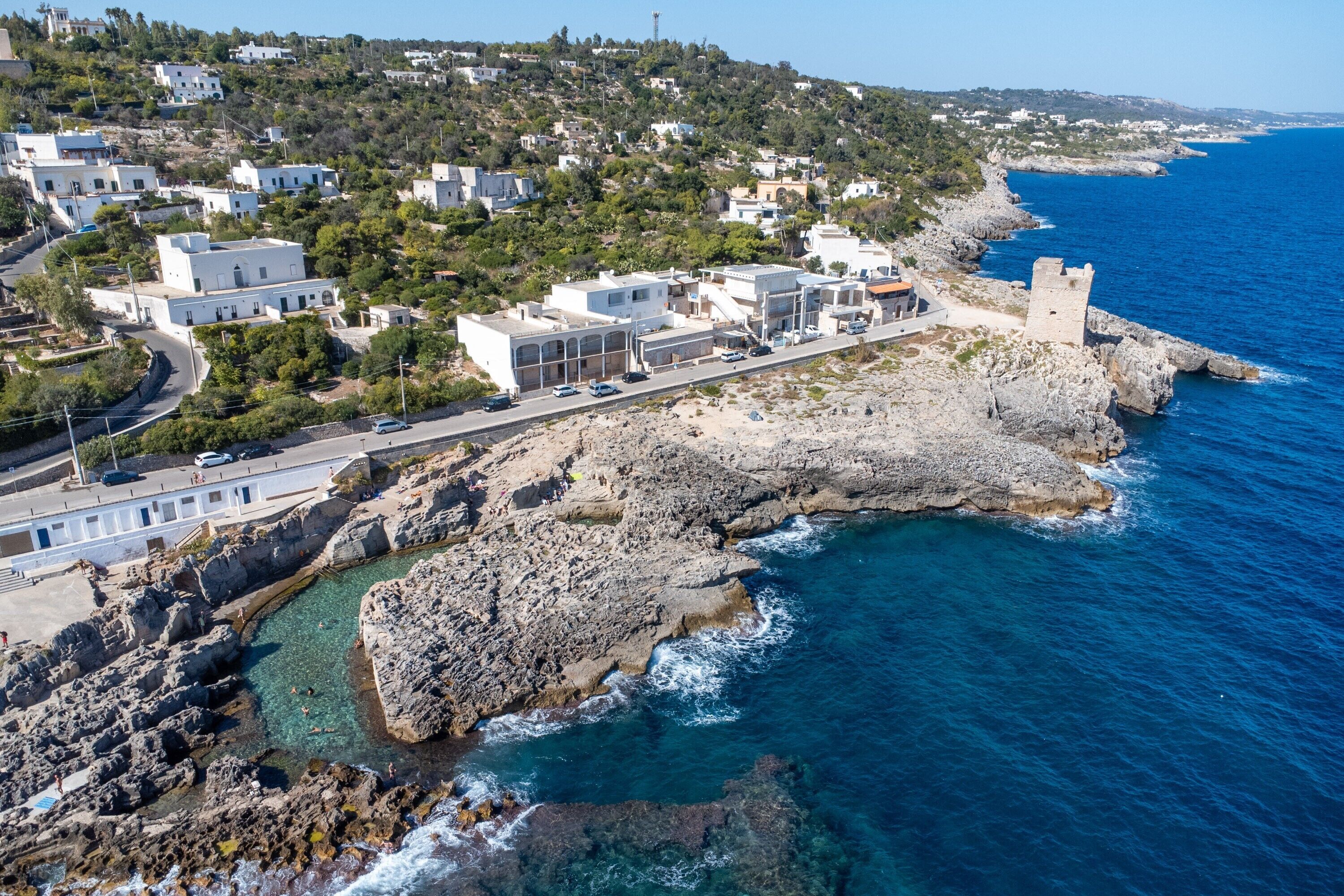 Une ville côtière avec des bâtiments, une route et une vue sur la mer.