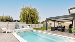 A swimming pool with lounge chairs, a covered patio area, and a lawn. - Villa "Bassin d'Arcachon" with Private Pool, Private Terraces and Wi-Fi (ARES)